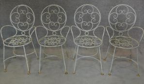 A set of four wrought iron and painted garden chairs. H.87cm