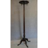 A mahogany coatstand with triple brass hooks on reeded column on quadruped carved cabriole