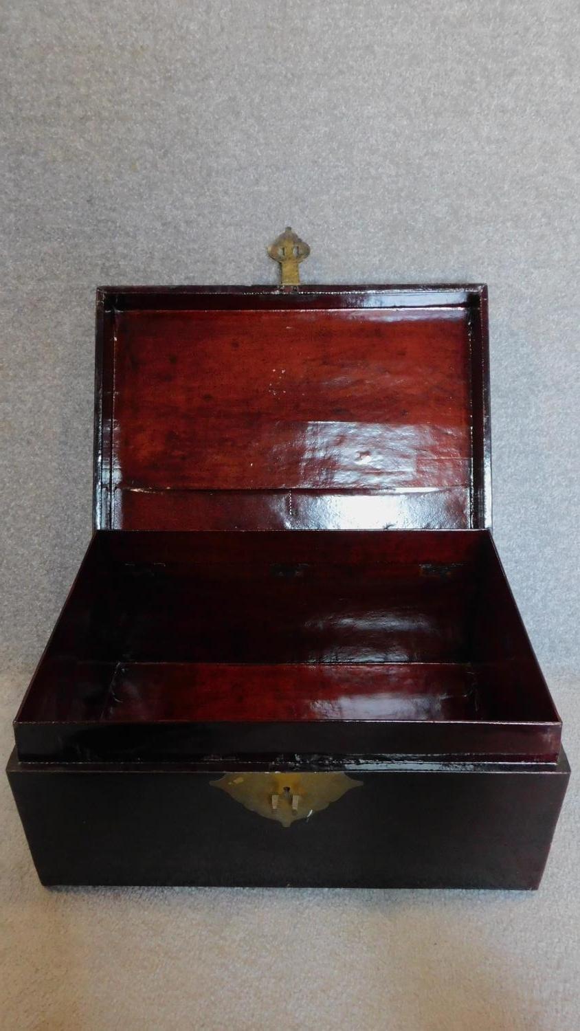 A Chinese black lacquered lidded box with brass lock and carrying handles. 31x63x42cm - Image 2 of 5