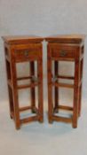 A pair of Chinese teak torcheres fitted frieze drawers. H.86 W.32 D.28cm