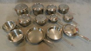 A large collection of stainless steel pots and saucepans.