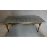 A 19th century pitch pine refectory dining table with studded zinc top on square tapering
