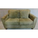 A 2 seater sofa in sage faux suede upholstery. 88x145x93cm