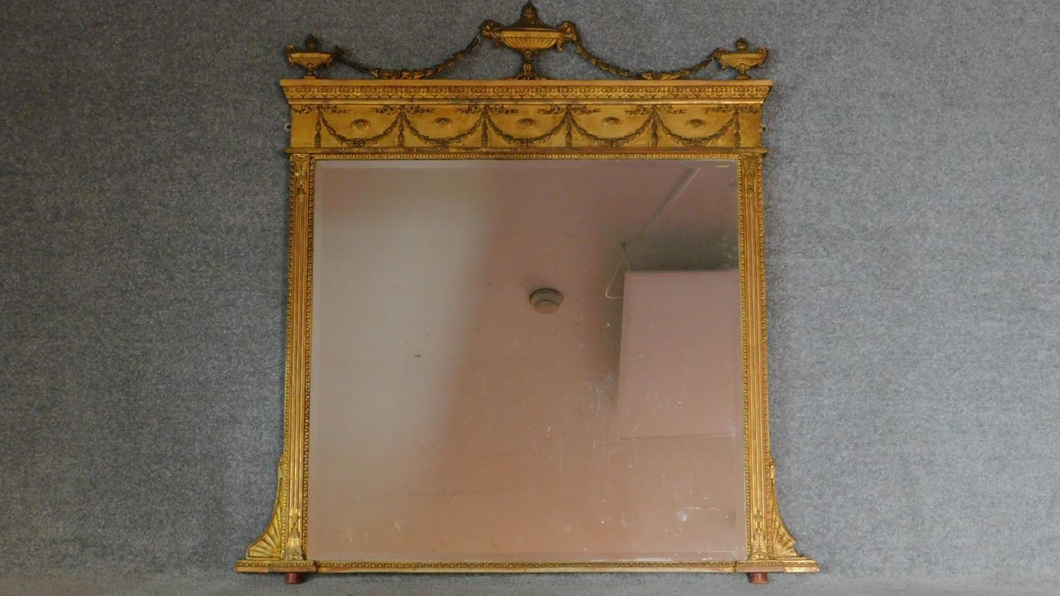 A 19th century Adam style giltwood overmantel mirror with swag and urn surmount and original