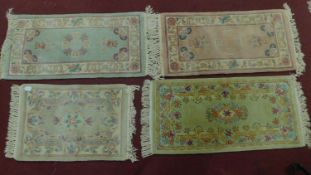 Four Chinese style rugs all with central floral medallions on a pastel field, framed with floral