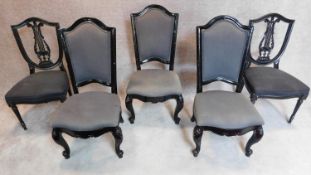A pair of black lacquered dining chairs and three French style chairs all in the same upholstery.