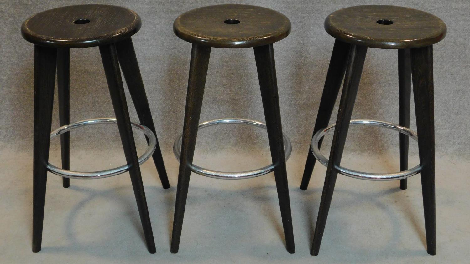 A set of three stained beech high stools. H.88cm