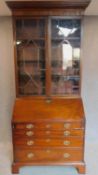 A Georgian mahogany bureau bookcase, the astragal glazed upper section above fall front revealing