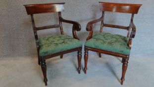A pair of William IV style mahogany armchairs in buttoned floral green upholstery on turned tapering