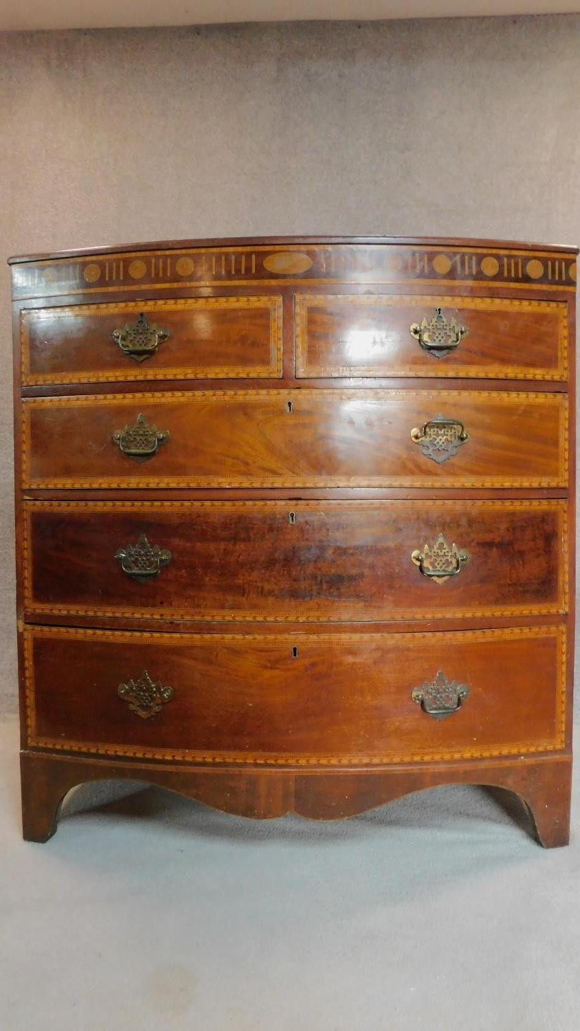A Georgian mahogany and satinwood inlaid bowfront chest of two short over three long drawers. H.