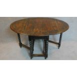 A Jacobean style carved oak drop flap dining table on bobbin turned supports. 76x135x92cm
