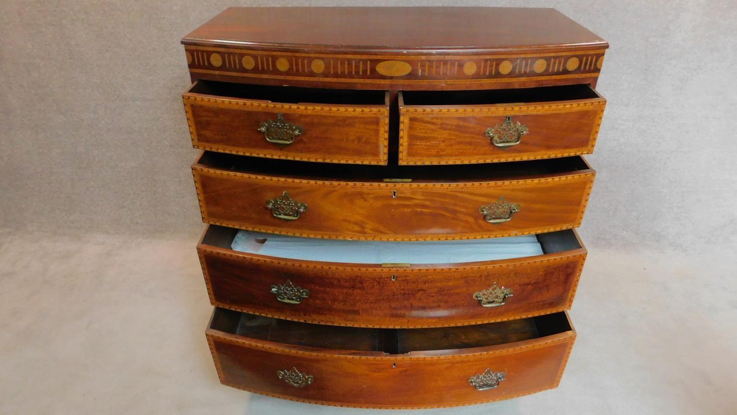 A Georgian mahogany and satinwood inlaid bowfront chest of two short over three long drawers. H. - Image 3 of 7