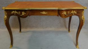 A walnut Louis XV style bureau plat of compact size with shaped tooled leather inset top with ormolu