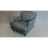 A Howard style upholstered armchair on mahogany turned tapering supports. H.88cm