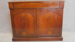 An early 19th century mahogany two door chiffonier fitted frieze drawer above arched panelled doors.