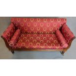 A William IV rosewood scroll end sofa in rouge and gold laurel wreath upholstery on turned fluted