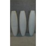 A set of three tall ovoid floor standing bases with ribbed boddies. H.84