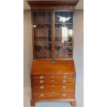 A Georgian mahogany bureau bookcase, the astragal glazed upper section above fall front revealing