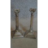 A pair of old silver plated Corinthian column candlesticks. H.30cm (one sconce missing)