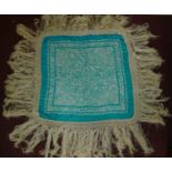 A Chinese embroided shawl with allover ivory figural decoration on a turquoise ground. 200x200cm