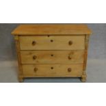 A 19th century Continental pine chest of drawers with carved side pilasters on turned bun feet.