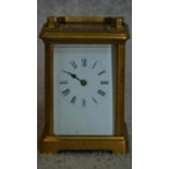 A brass cased carriage clock with white enamel dial. (missing minute hand and one glass side