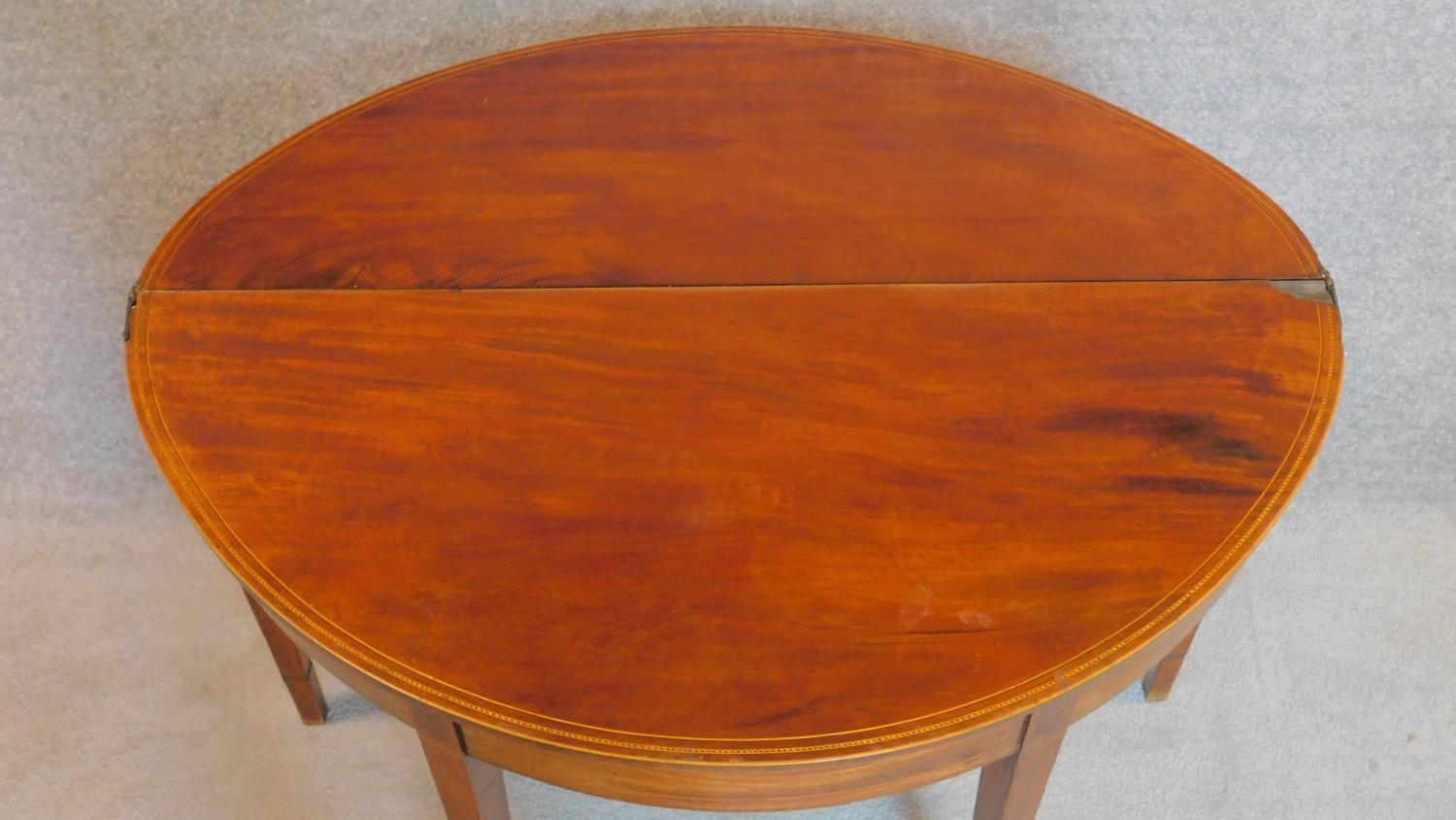 A Georgian mahogany and satinwood strung demi lune foldover top card table on square tapering - Image 3 of 8