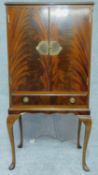 A Georgian style flame mahogany drinks cabinet with mirrored glass interior. H.129 W.66 D.42cm