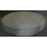 A large oval upholstered ottoman. H.27 W.123 D.95cm