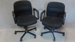 A pair of black upholstered swivel office desk chairs. H.90cm