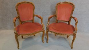 A pair of French carved beech framed open armchairs in blush upholstery on cabriole supports. H.96cm