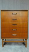 A mid 20th century teak chest of five long drawers. H.107 W.76 D.42cm