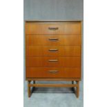 A mid 20th century teak chest of five long drawers. H.107 W.76 D.42cm
