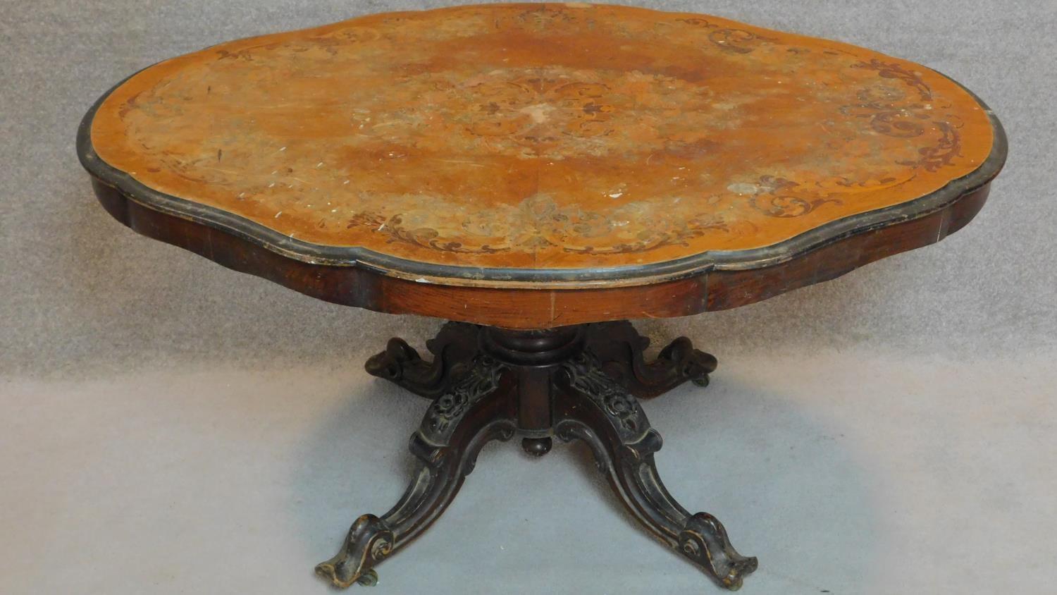 A late 19th century walnut and marquetry inlaid shaped top dining table on well carved quadruped