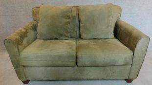 A 2 seater sofa in sage faux suede upholstery. 88x145x93cm