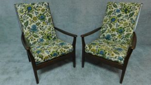 A pair of mid 20th century stained beech framed armchairs in floral upholstery by Cintique, maker