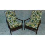 A pair of mid 20th century stained beech framed armchairs in floral upholstery by Cintique, maker