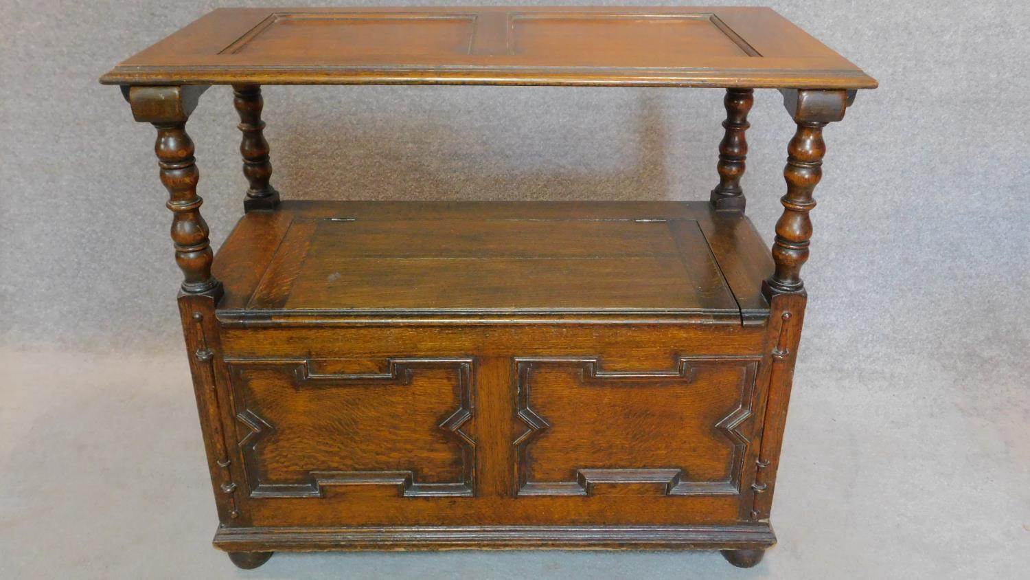 A mid 20th century oak Jacobean style monk's bench with sliding metamorphic back. H.78 W.93 D.46cm