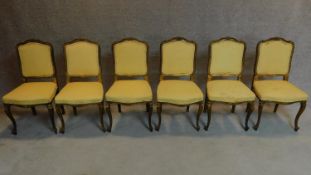 A set of six 19th century gilt framed lemon upholstered dining chairs on carved cabriole supports.