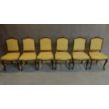 A set of six 19th century gilt framed lemon upholstered dining chairs on carved cabriole supports.