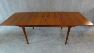 A mid 20th century teak extending dining table with patent action leaves, by McIntosh, makers