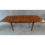 A mid 20th century teak extending dining table with patent action leaves, by McIntosh, makers