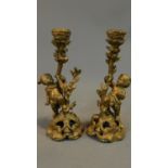 A pair of rococo style gilt candelabra, vinery supported by cherubs. H.27cm