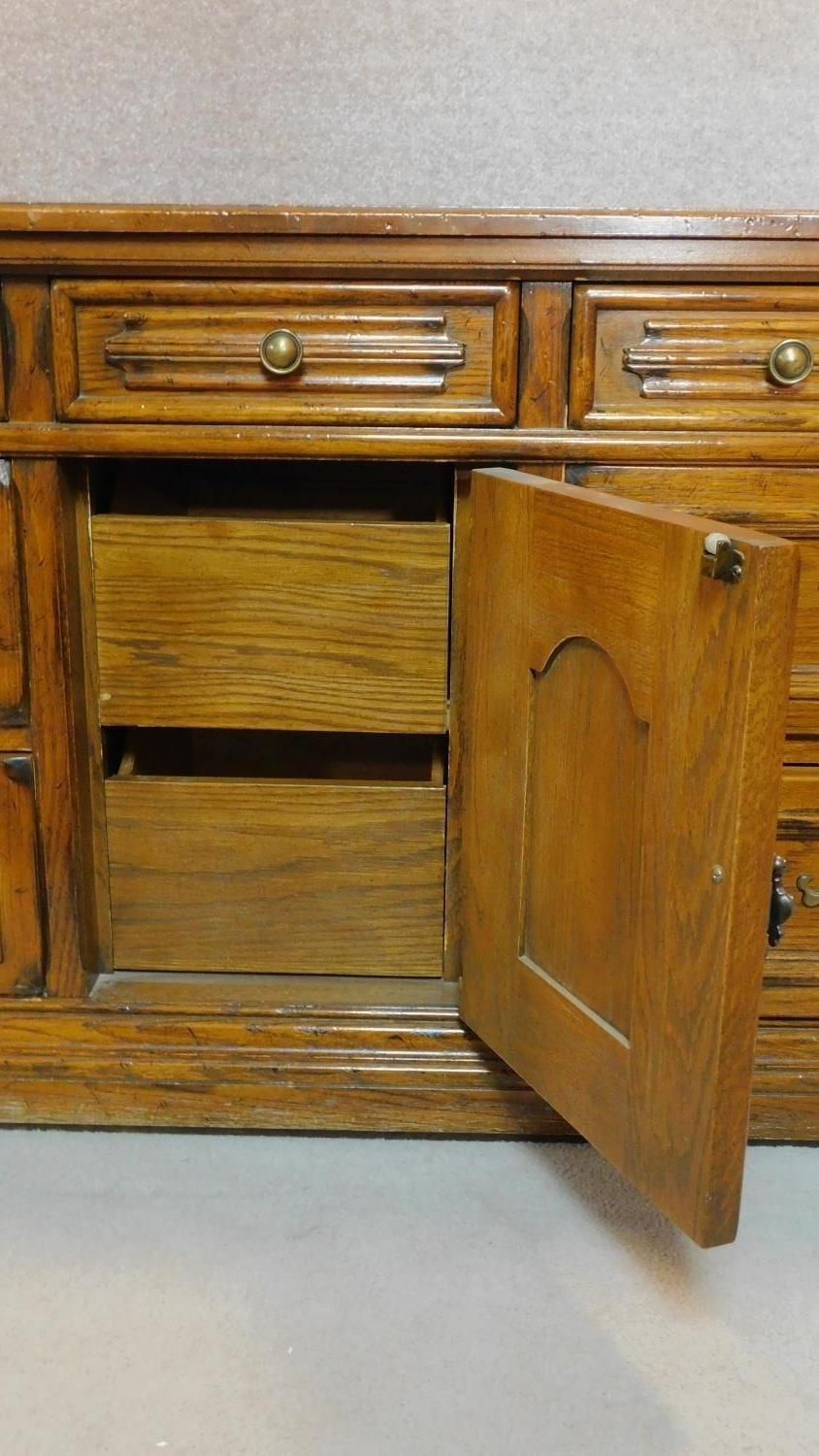 A French provincial style oak sideboard fitted with an arrangement of drawers and a central cupboard - Image 3 of 6