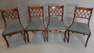 A set of four mahogany Regency style dining chairs on sabre supports. H.81cm