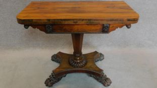 A Regency rosewood foldover top card table with baize lined interior on well carved pedestal and