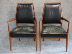 A pair of mid 20th century Danish teak open armchairs in deep green leather upholstery. H.97