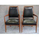 A pair of mid 20th century Danish teak open armchairs in deep green leather upholstery. H.97