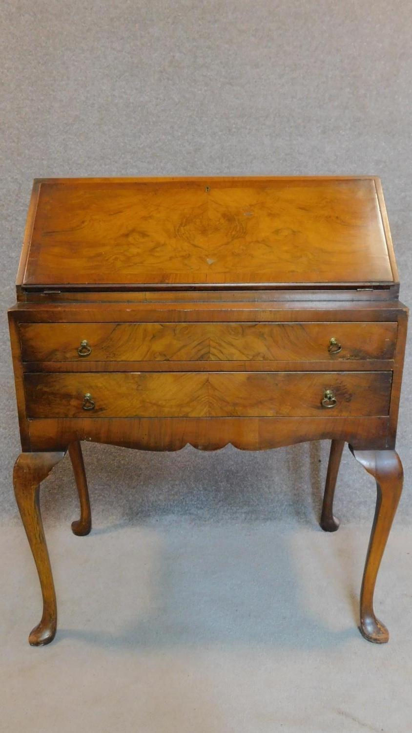 A mid Georgian style burr walnut bureau with fall front enclosing a fitted interior on cabriole