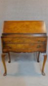 A mid Georgian style burr walnut bureau with fall front enclosing a fitted interior on cabriole